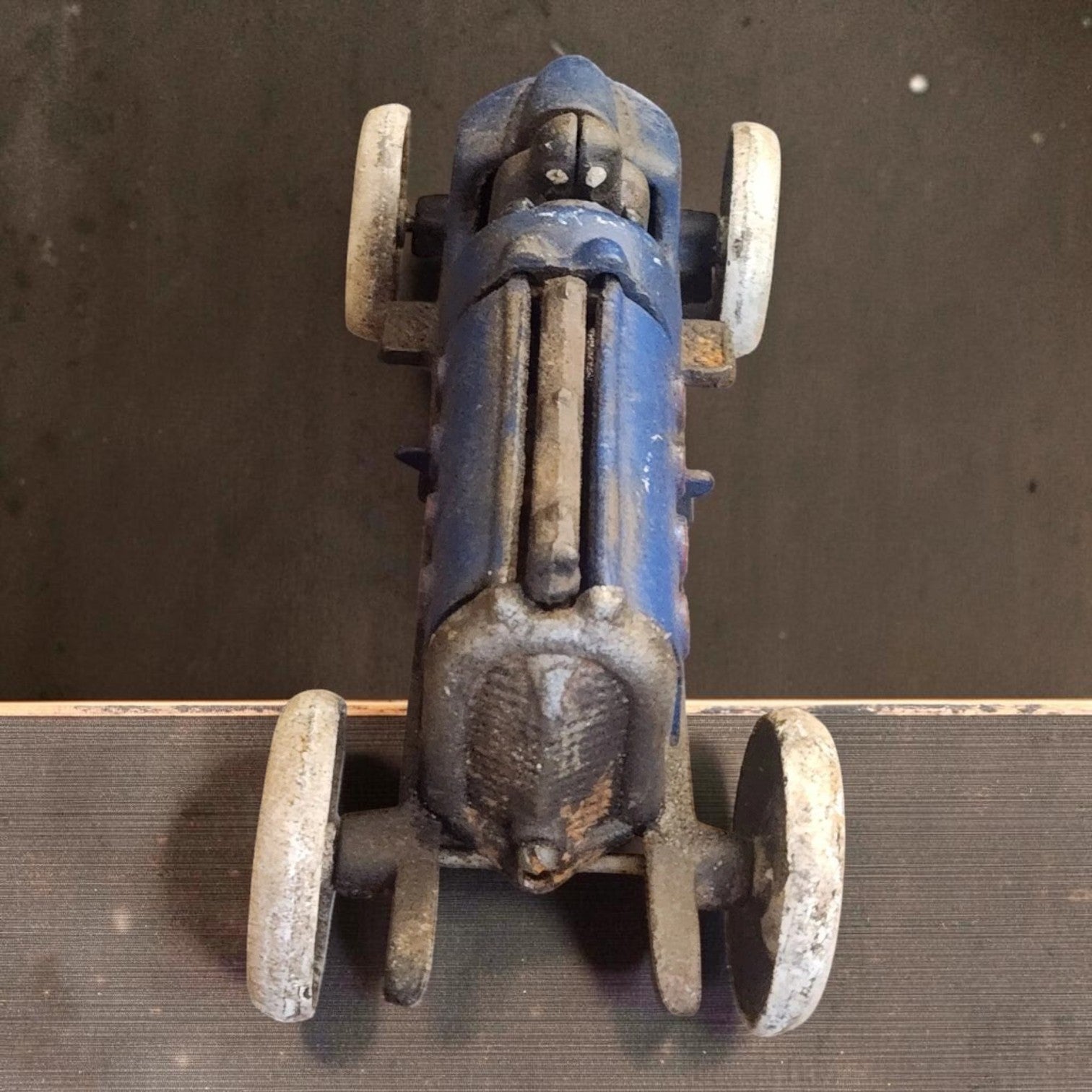 Jones Peak blue cast iron toy racer car with white wheels and antique patina finish. Moving details.