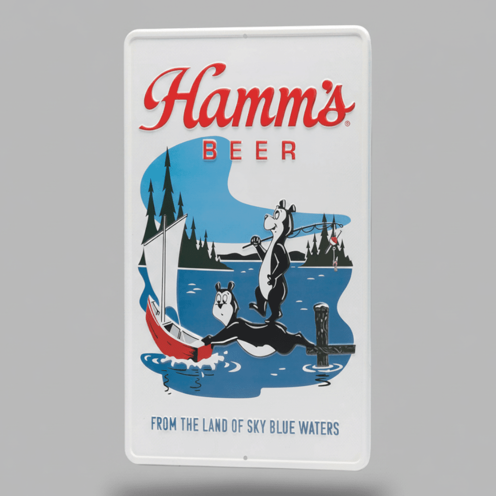 Jones Peak embossed metal Hamm’s Beer sign featuring two fishing bears and a sailboat in a vintage lake scene.