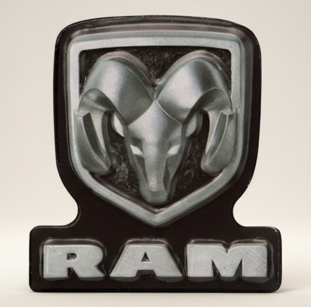 Jones Peak Ram embossed metal magnet with silver ram head and black background. Features "RAM" text.