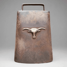 Jones Peak rustic cast iron cow bell with an antique patina finish and a decorative steer head emblem.