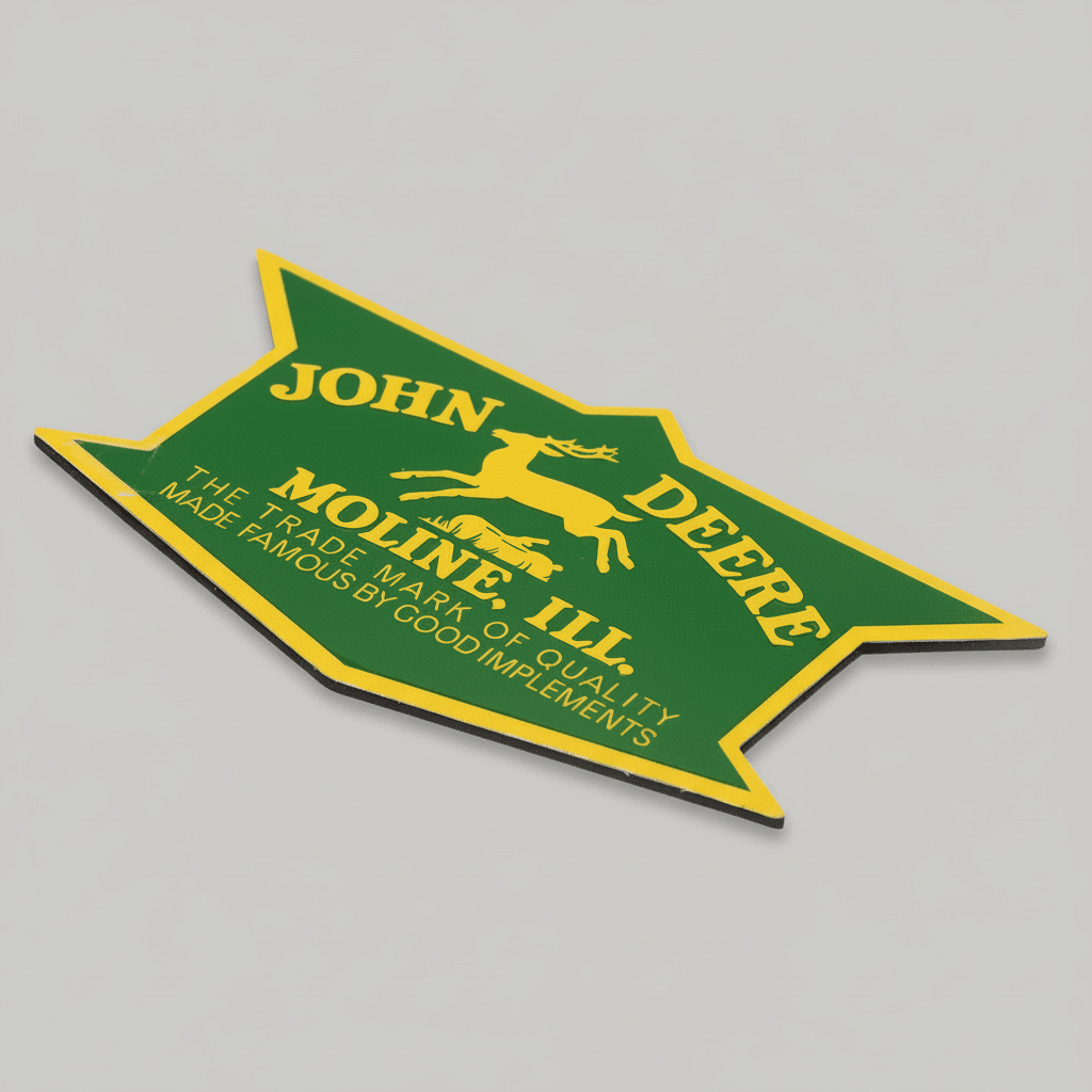 Angled view of the green and yellow John Deere Moline, Ill. metal magnet showing its thin profile.