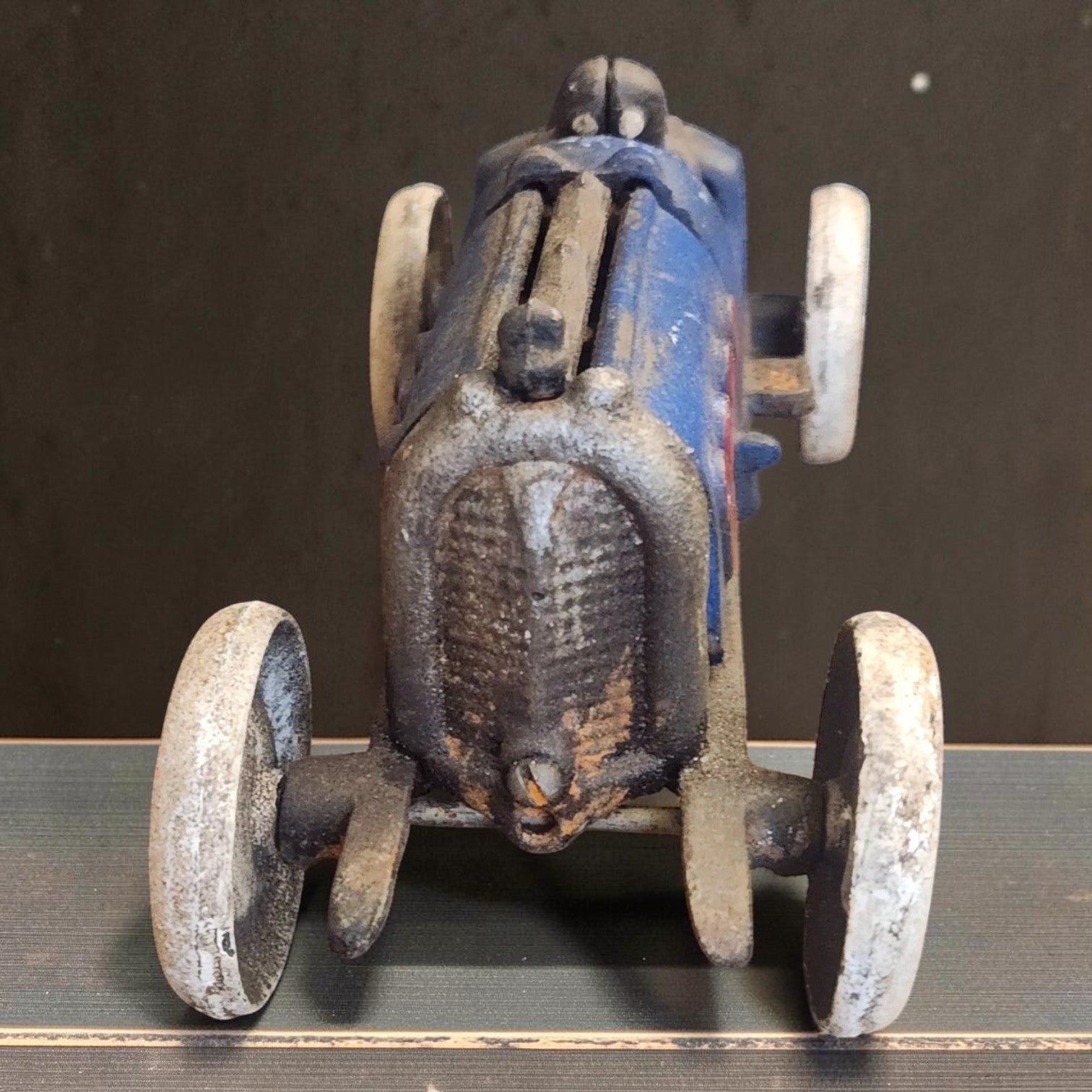 Jones Peak blue cast iron toy race car with white wheels and an antique patina finish, perfect for display.