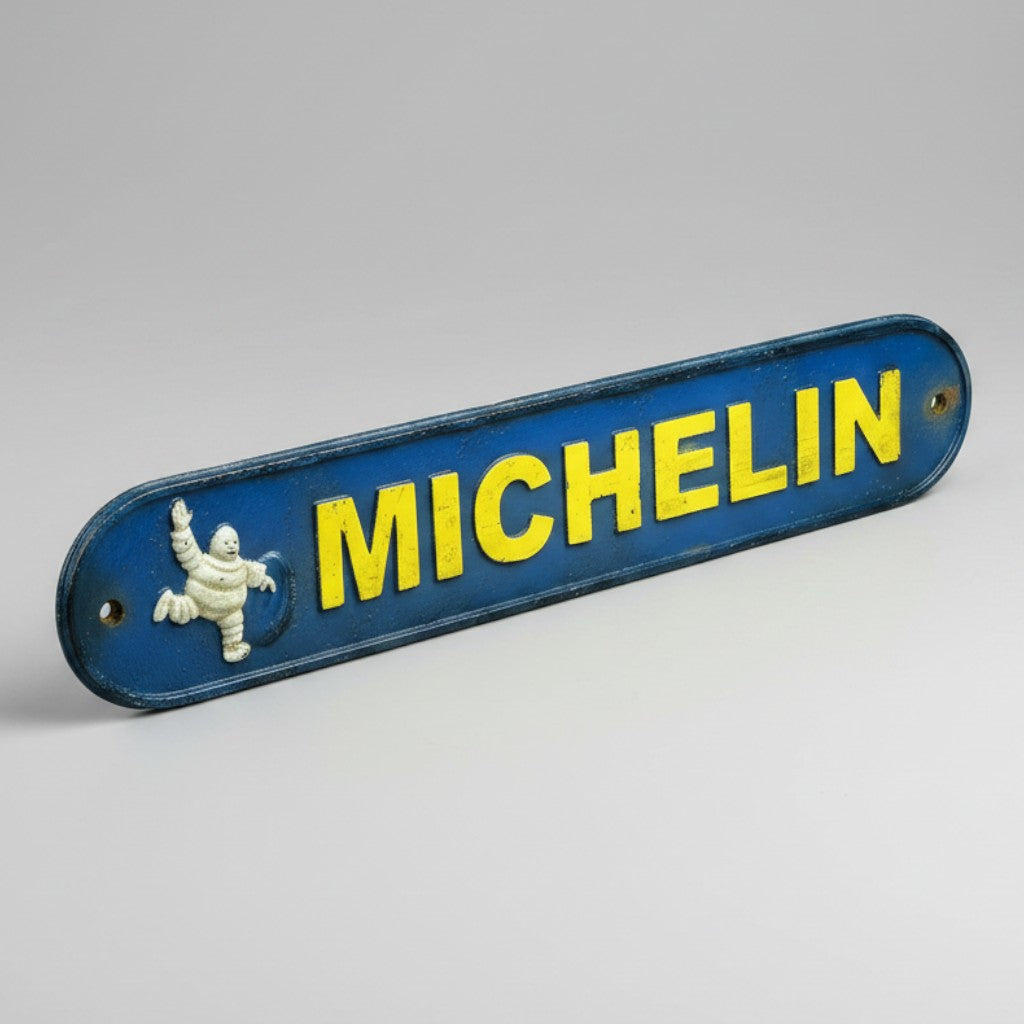 Jones Peak vintage Michelin Man cast iron plaque with blue background, yellow lettering, and antique patina finish.