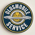 Jones Peak Oldsmobile Service round embossed metal magnet with vintage logo and globe design.