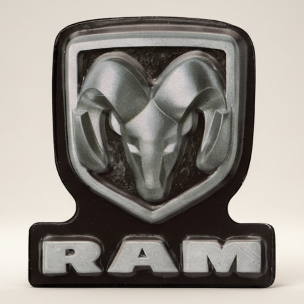 Jones Peak Ram embossed metal magnet with silver ram head and black background. Features "RAM" text.
