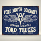 Jones Peak Ford Trucks 100 Years metal sign with Ford Motor Company logo and wings, distressed blue finish.