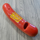 Jones Peak red plastic hot dog novelty whistle with yellow Oscar Mayer logo, 2 inches long.