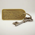 Jones Peak reproduction brass hotel key tag for Hotel de Paris, Georgetown, CO. Features antique finish and decorative floral elements.