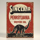 Jones Peak Sinclair Pennsylvania Motor Oil metal sign with a black dinosaur graphic and distressed red background.